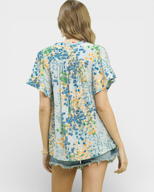 Woman wearing a floral blouse with a plain background