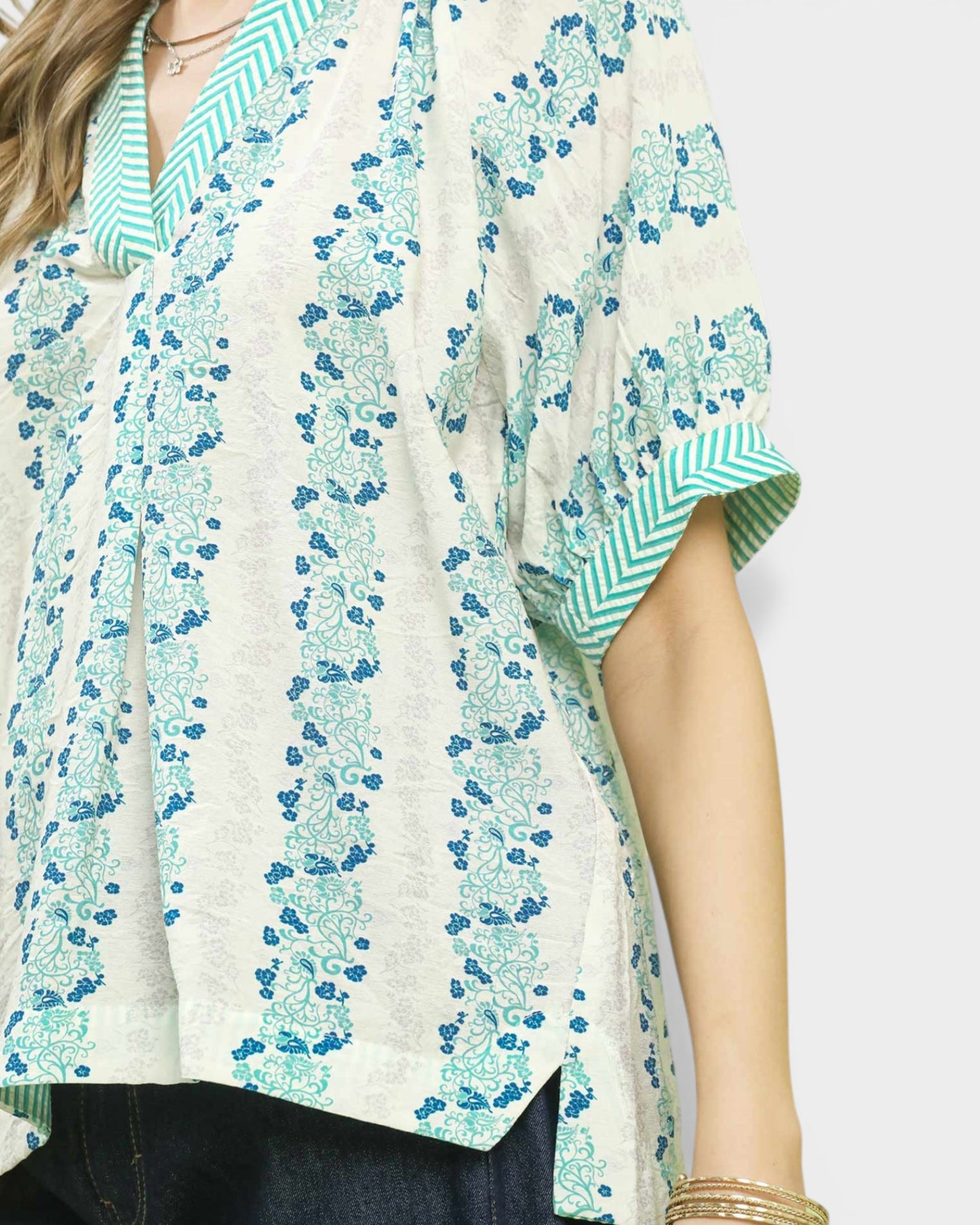 Floral patterned shirt with green and blue design on a plain background