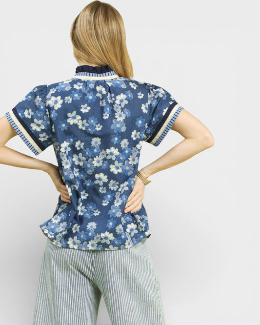 Woman wearing a blue floral blouse with white background