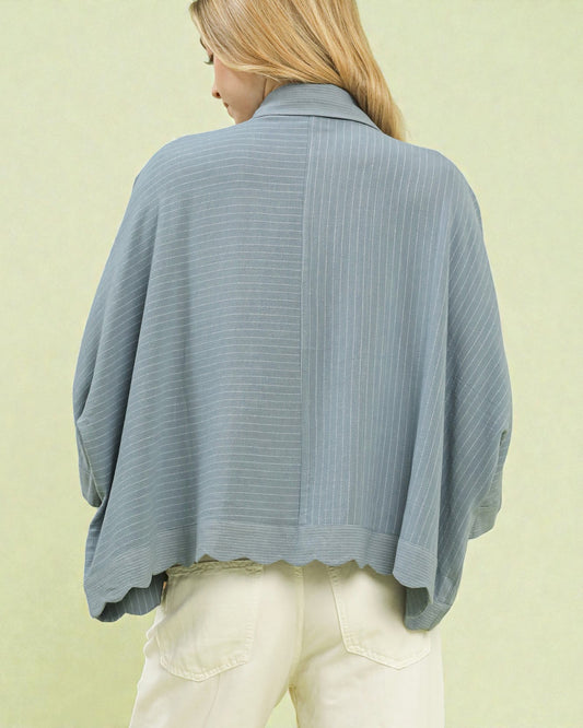 Woman wearing a light blue ribbed sweater against a light green background
