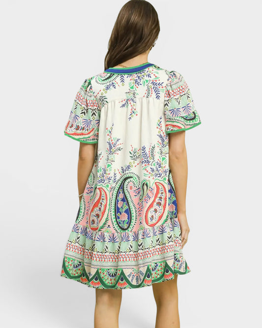 Woman wearing a colorful patterned dress on a white background