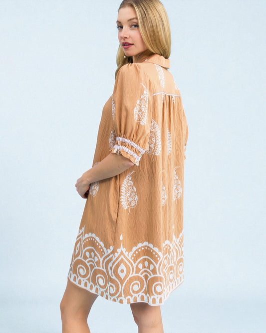 Woman wearing a beige dress with white lace details on a light blue background