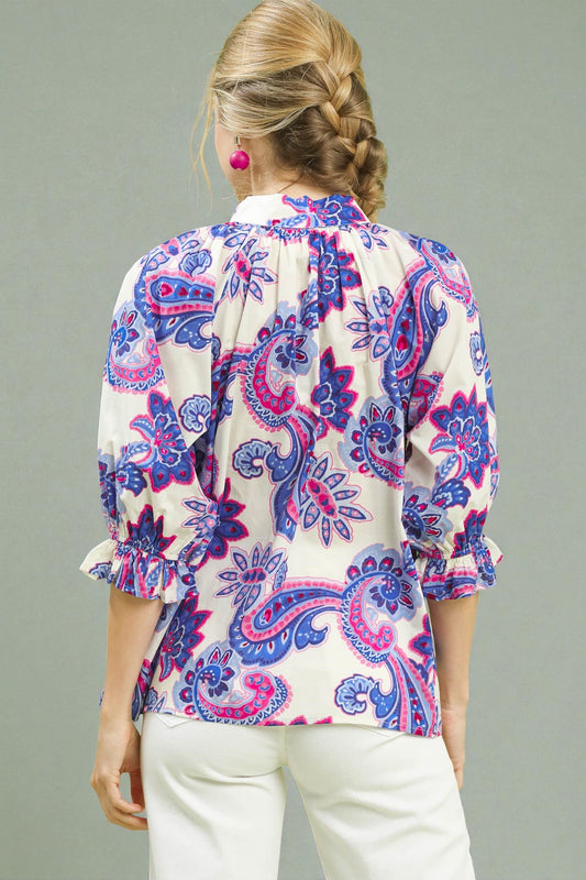 Woman wearing a patterned blouse with a gray background