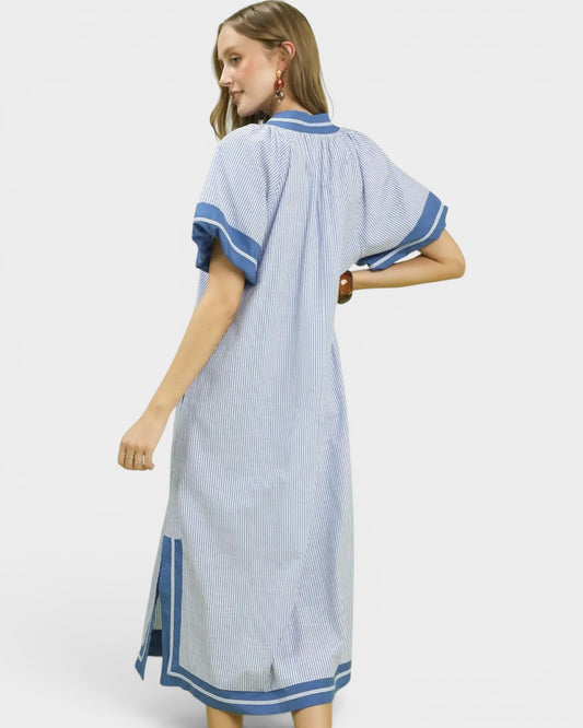 Woman wearing a blue and white striped dress on a white background