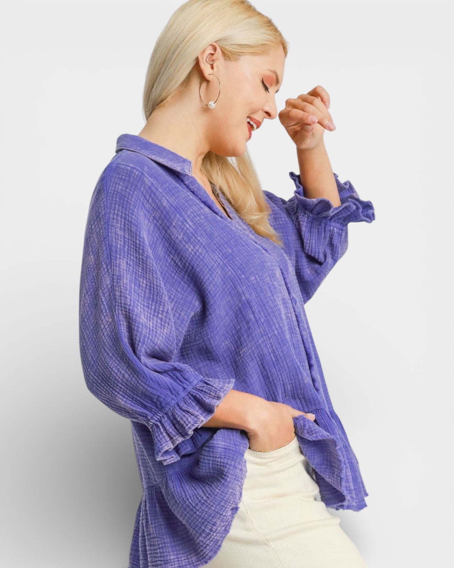 Woman wearing a purple textured blouse against a white background
