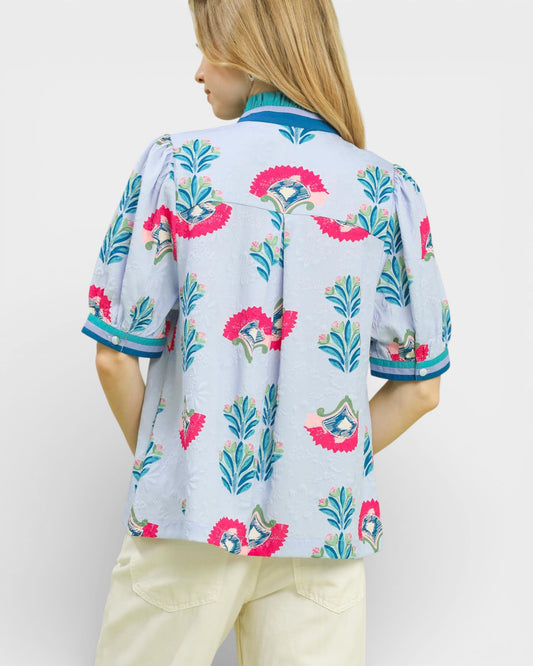 Woman wearing a colorful floral blouse with a white background