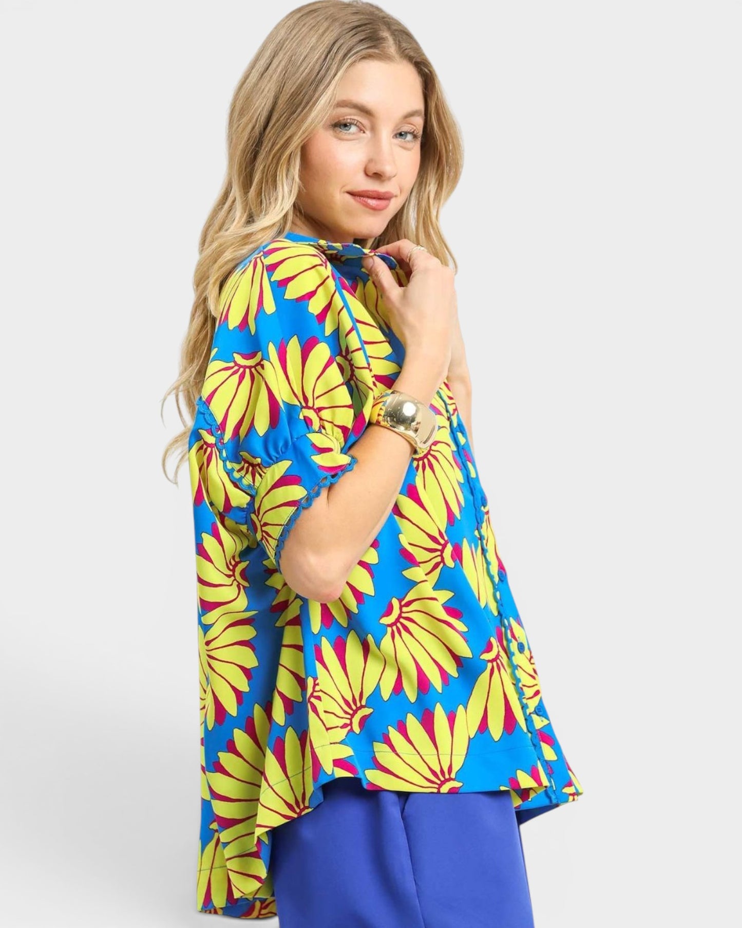 Woman wearing a colorful floral blouse with a plain background