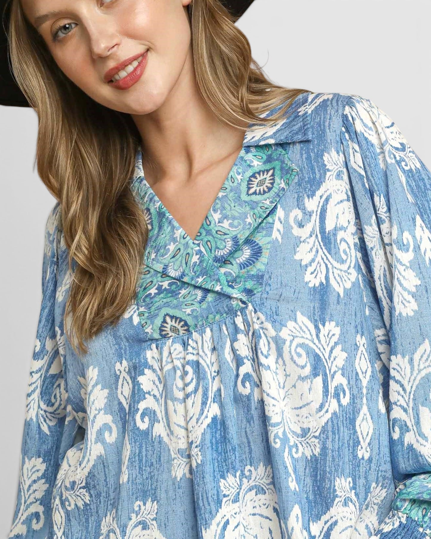 Woman wearing a blue patterned dress with a plain background
