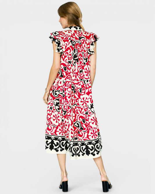 Woman wearing a red, black, and white patterned dress on a white background