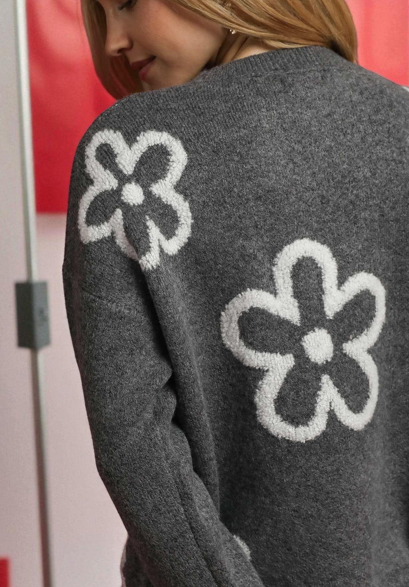 Gray sweater with white flower patterns on a blurred background