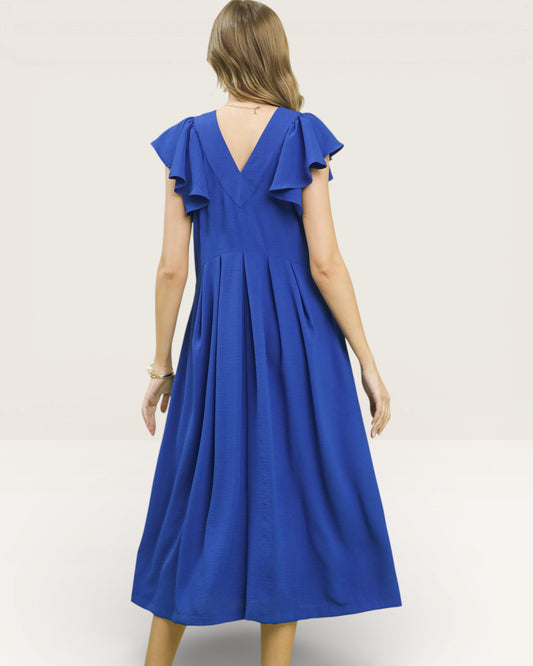 Woman wearing a blue dress with ruffled sleeves on a plain background