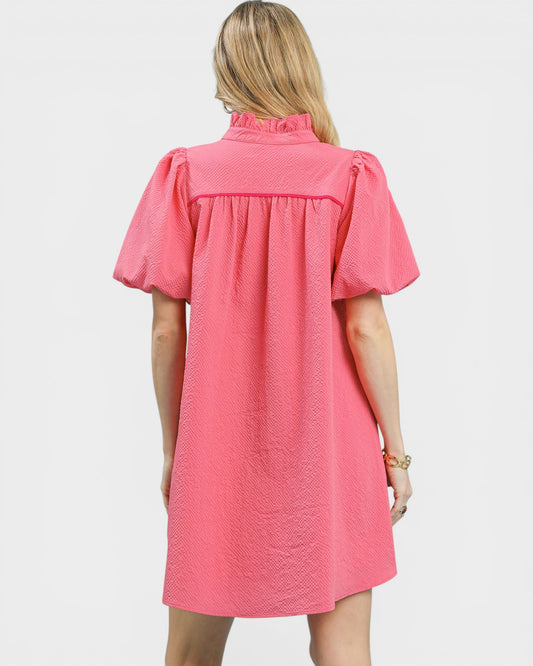 Woman wearing a pink dress with short sleeves on a white background