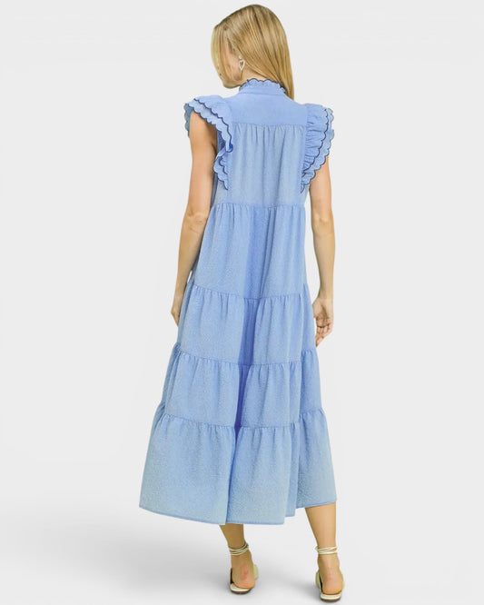 Woman wearing a light blue dress with ruffled sleeves on a white background