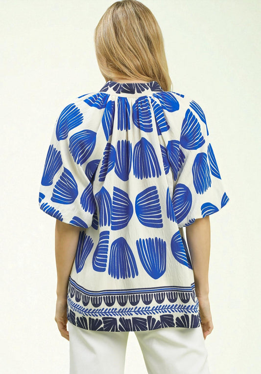 Woman wearing a blue and white patterned blouse on a white background