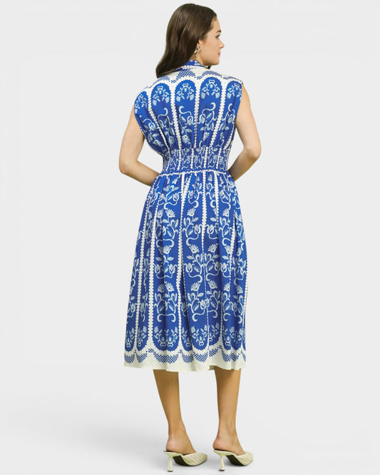 Woman wearing a blue and white patterned dress on a light gray background