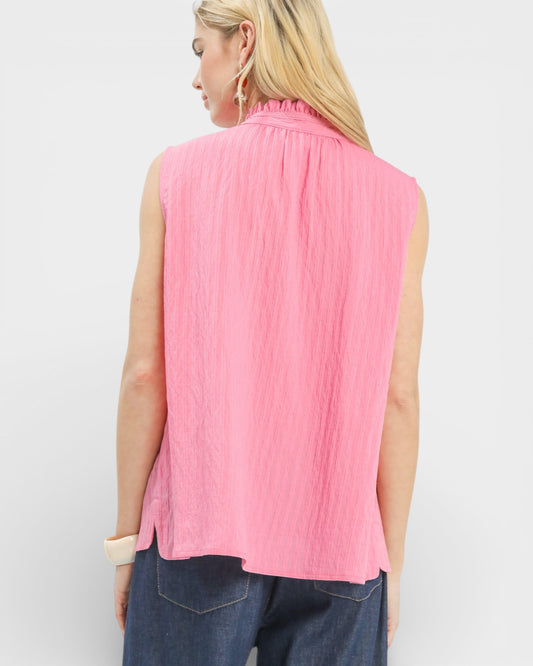 Woman wearing a pink sleeveless top against a white background