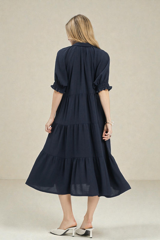 Woman wearing a navy blue dress with a plain background