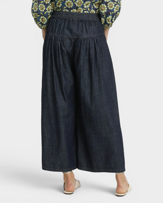 Dark denim pants worn by a person on a white background
