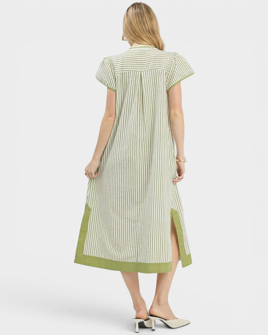 Woman wearing a green and white striped dress on a white background