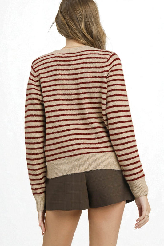 Person wearing a striped sweater and shorts on a white background