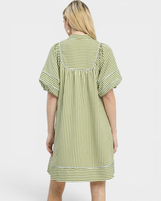 Woman wearing a green and white striped dress on a white background