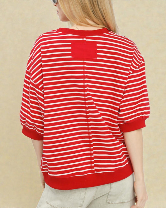 Red and white striped shirt worn by a person on a beige background
