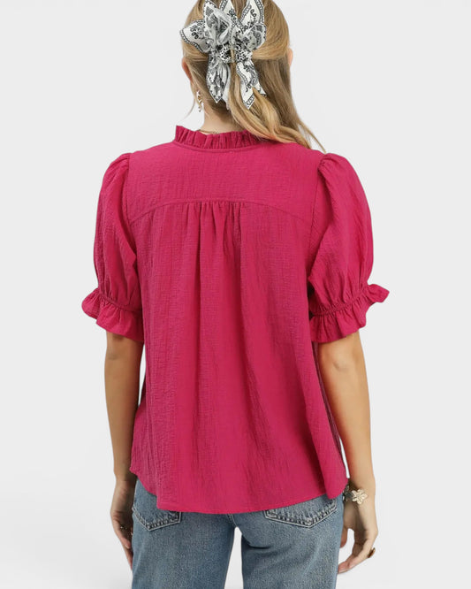 Person wearing a pink blouse with puffed sleeves on a white background