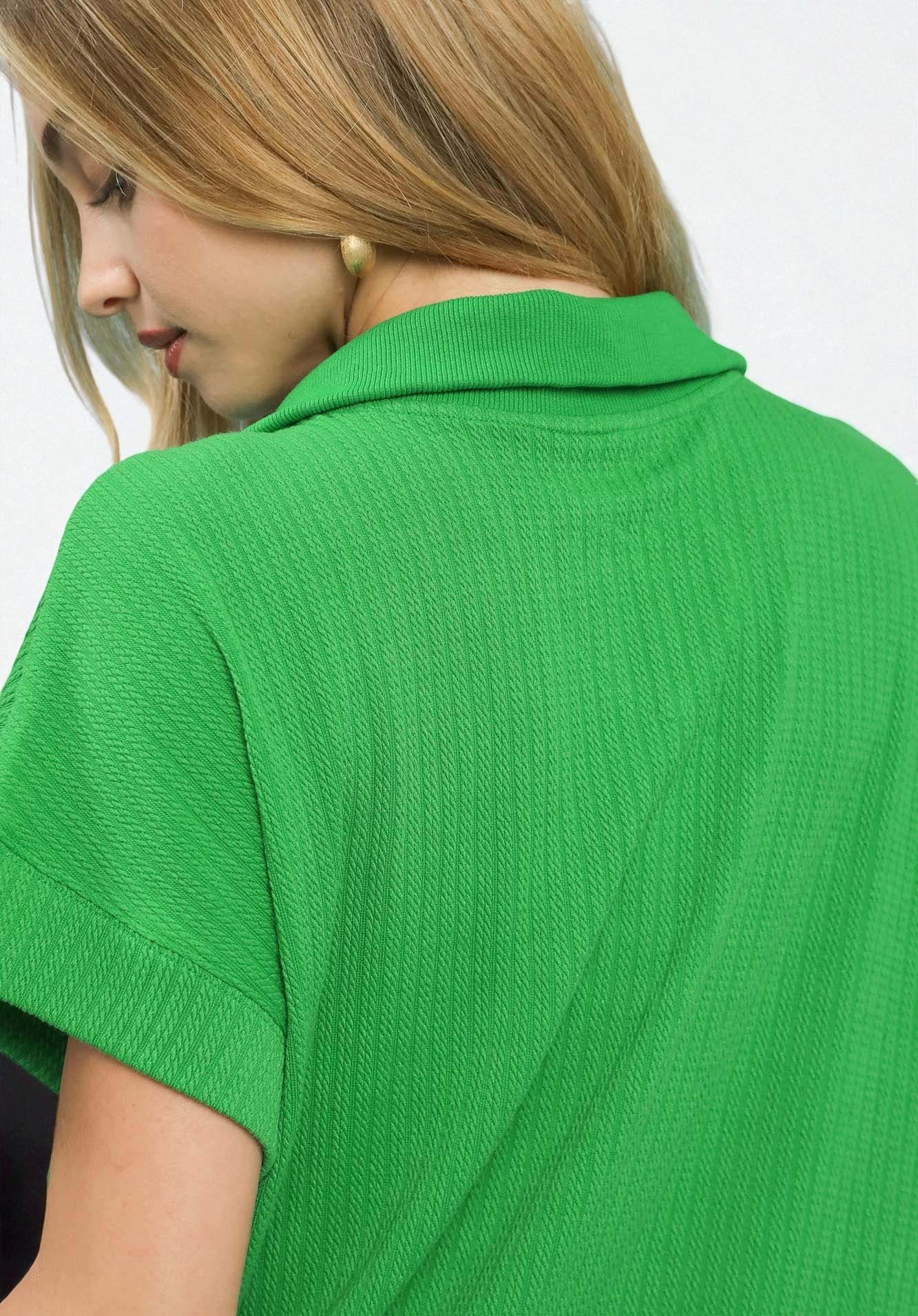 Green ribbed sweater worn by a person with a neutral background