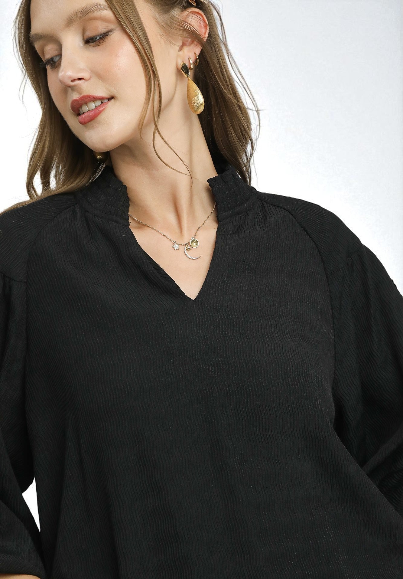 Woman wearing a black top with a plain background