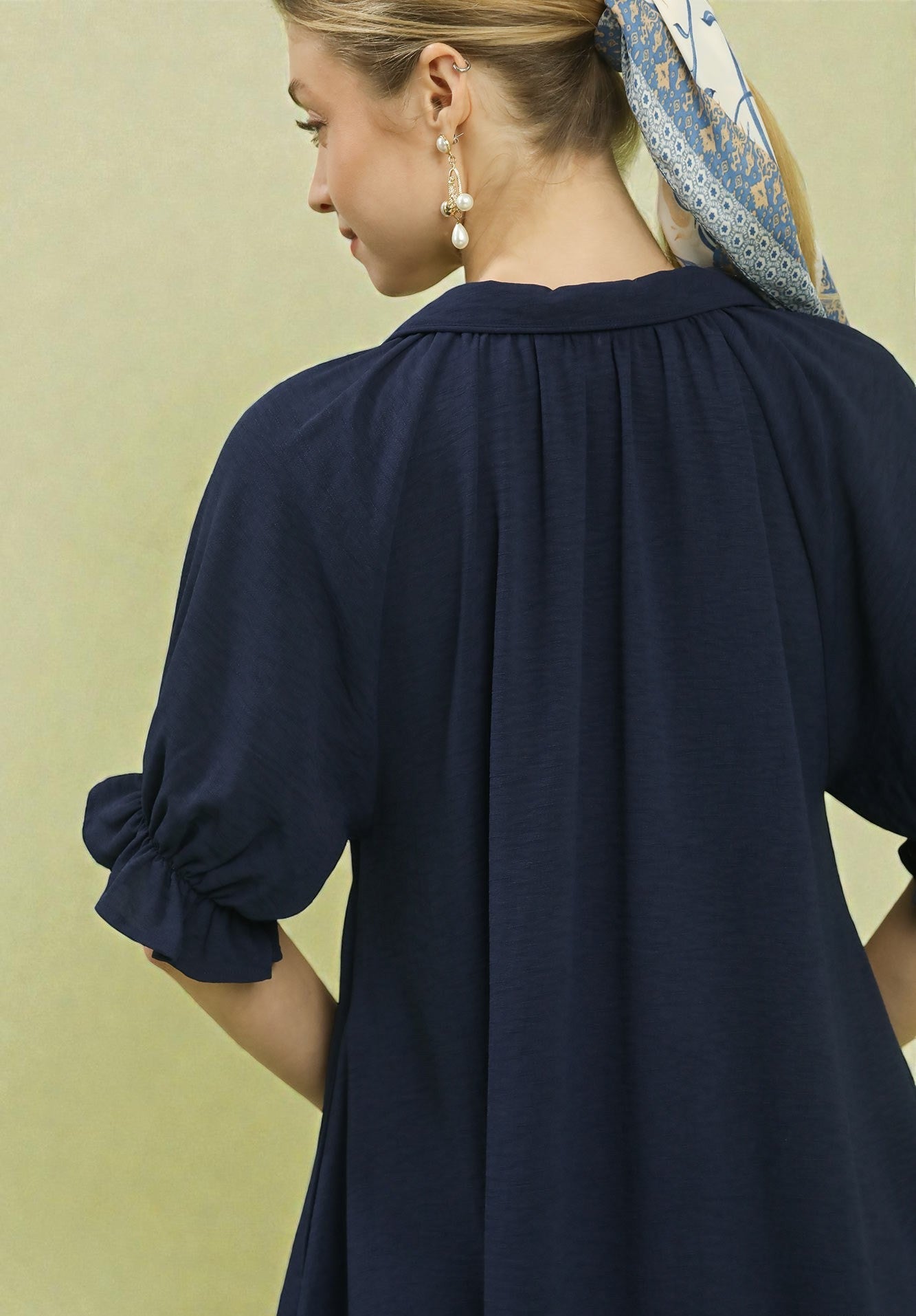 Woman wearing a navy blue dress with a plain background