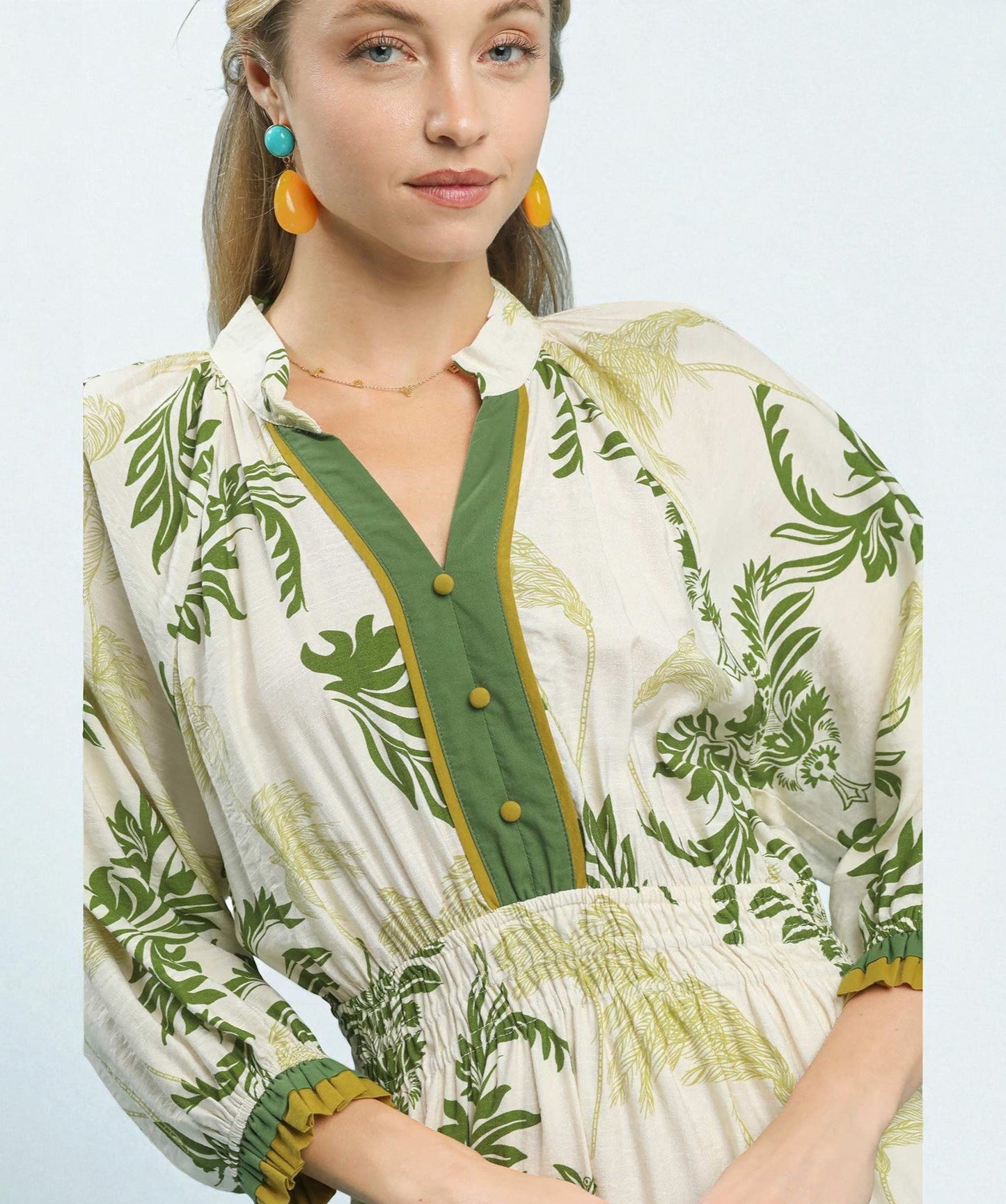 Woman wearing a green and white patterned dress with a plain background