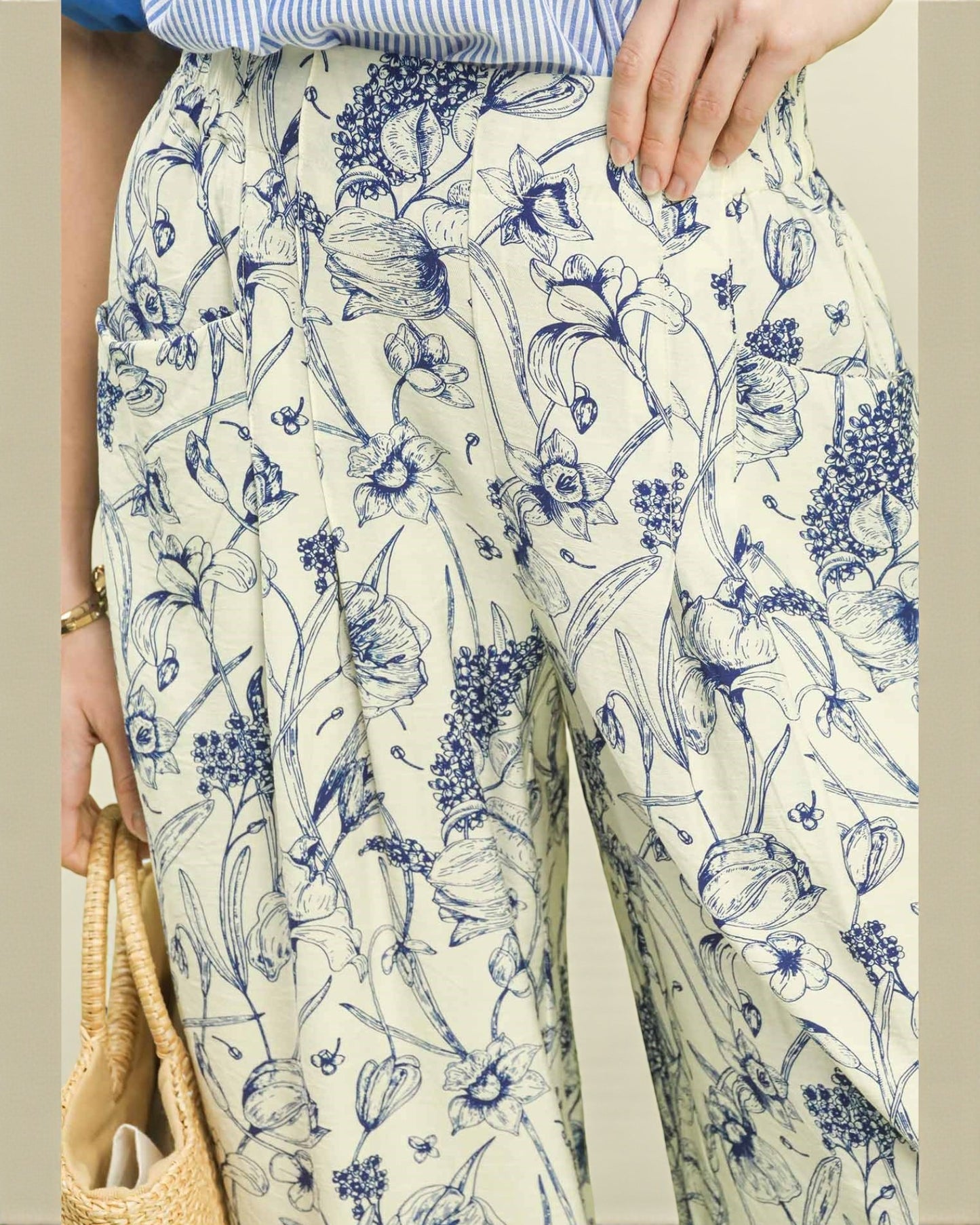 Person wearing a floral patterned dress with blue and white flowers on a beige background