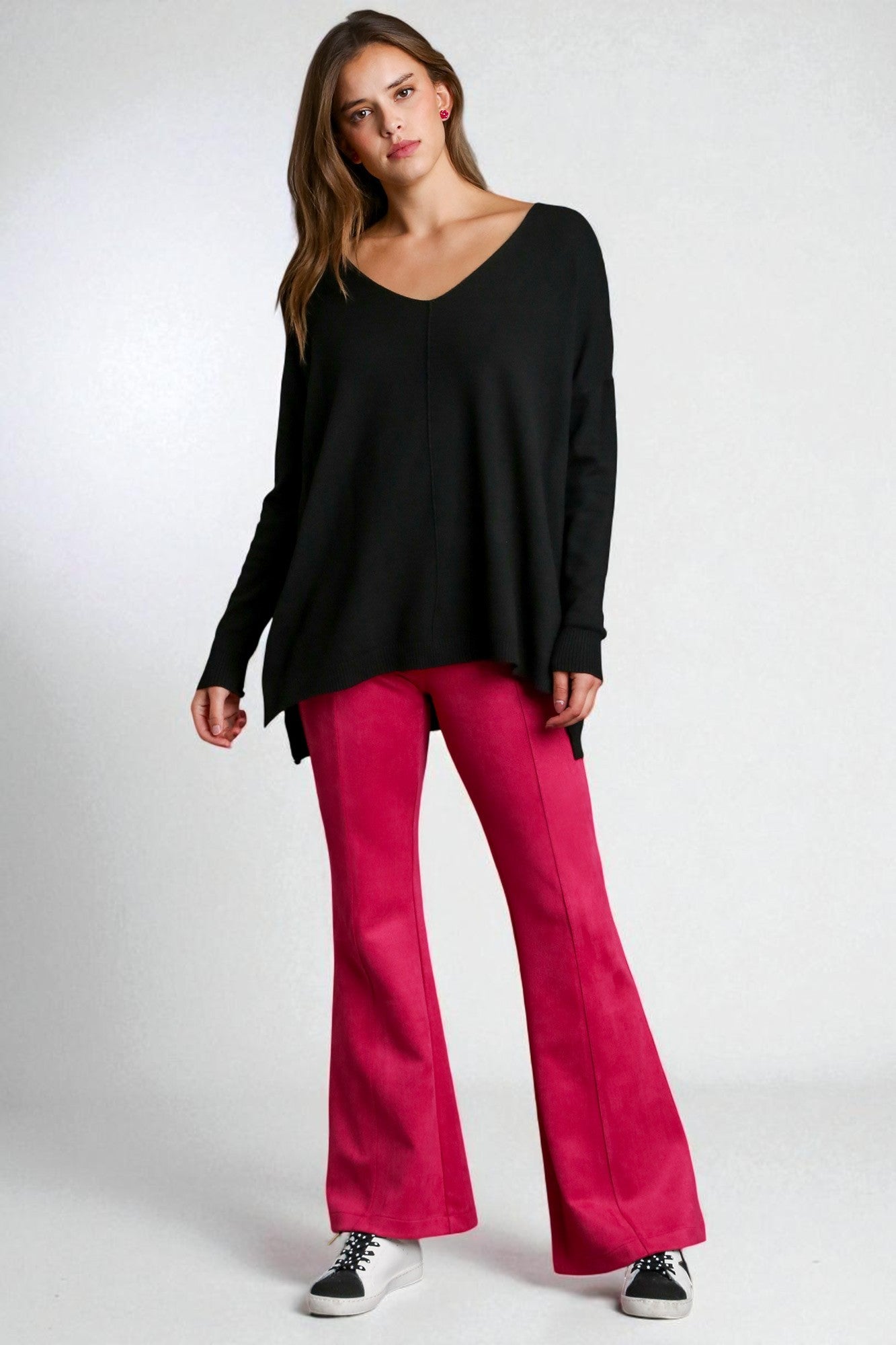 Woman wearing a black top and pink pants on a white background
