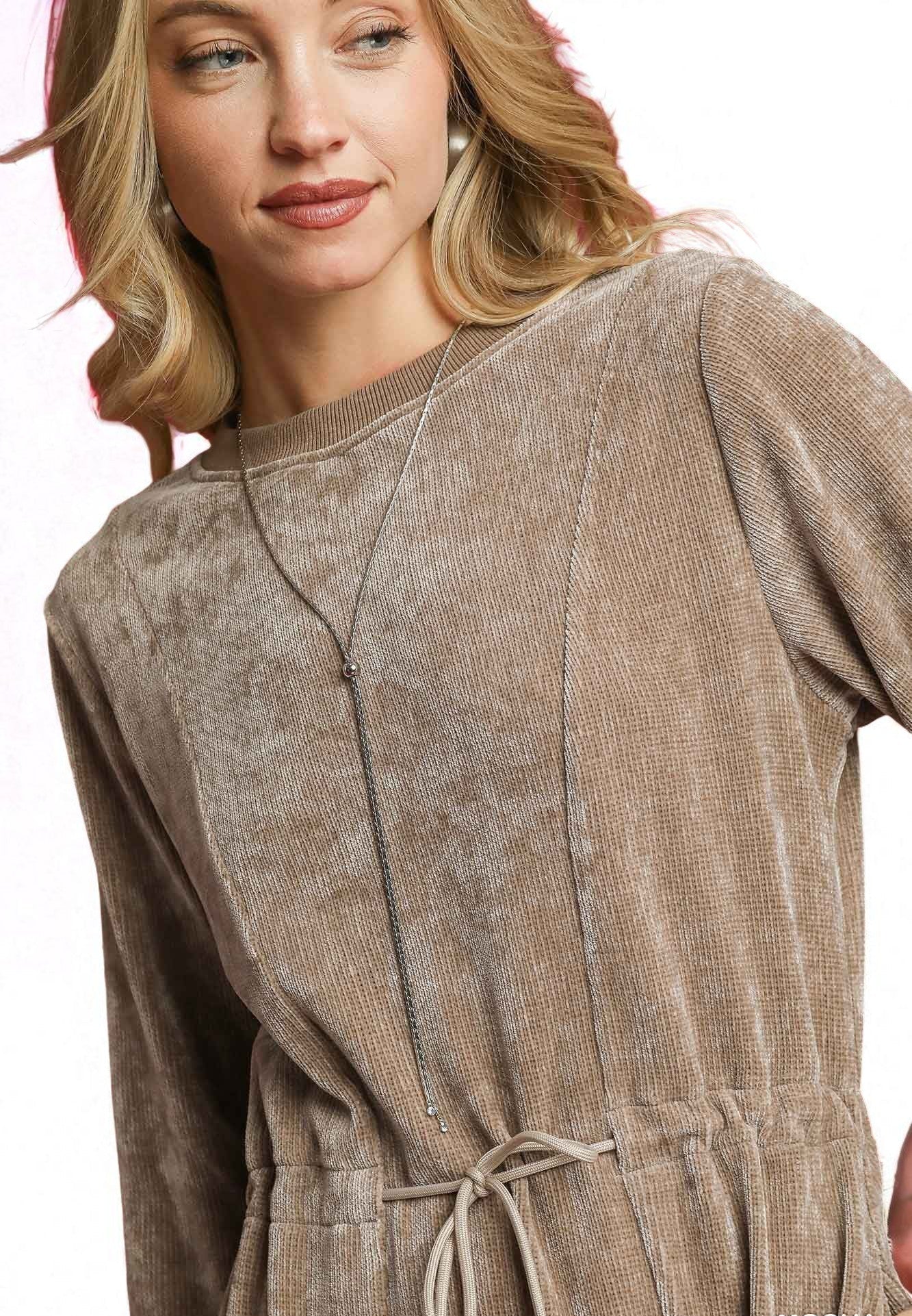 Woman wearing a brown textured dress with a plain background