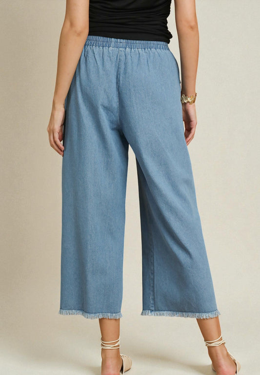 Person wearing blue denim pants on a beige background