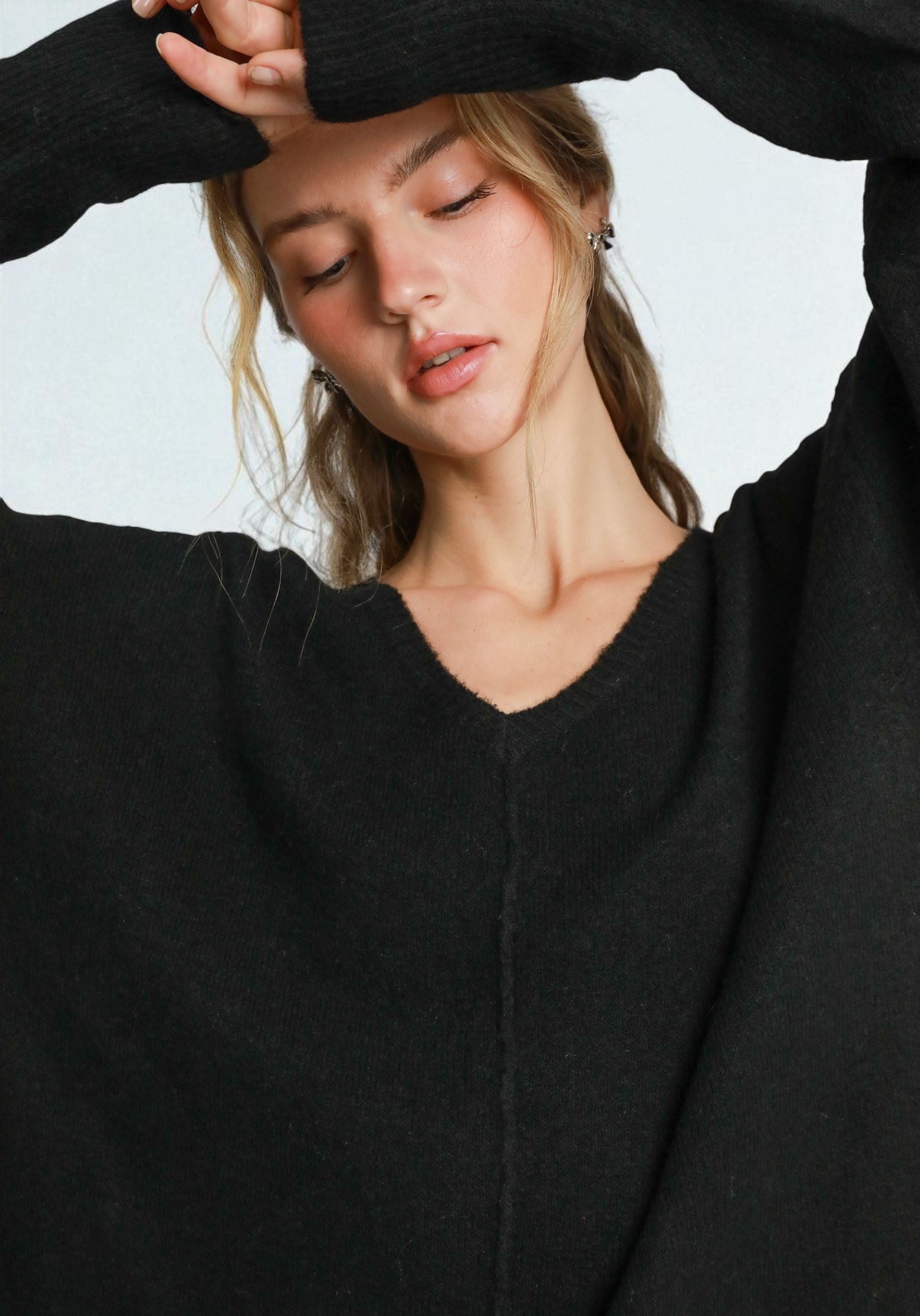 Woman wearing a black sweater against a light background