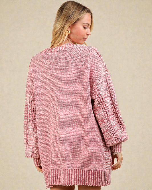 Woman wearing a pink textured cardigan against a beige background