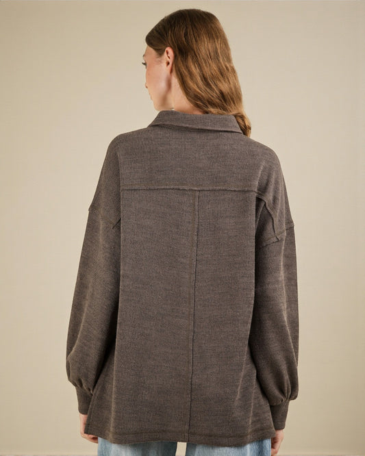 Person wearing a brown jacket on a beige background