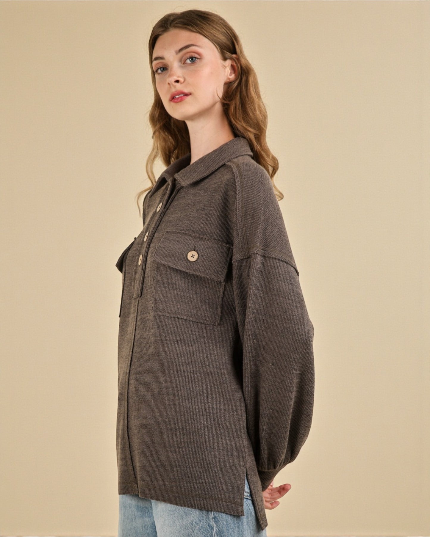 Woman wearing a brown jacket on a beige background