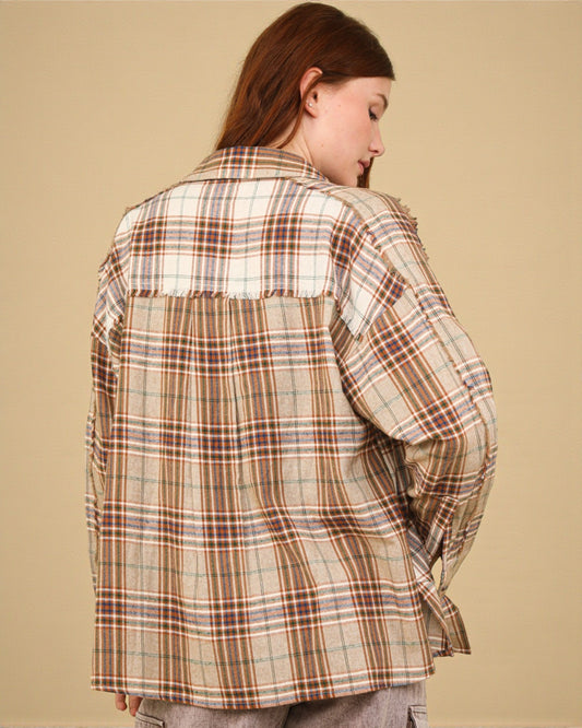 Person wearing a plaid shirt against a beige background