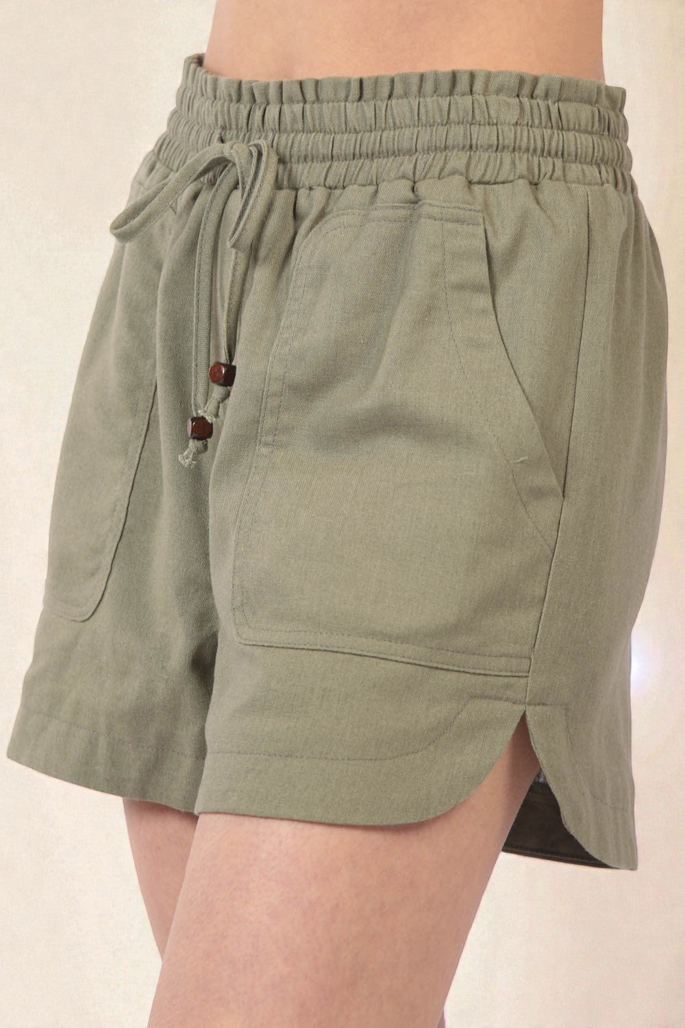 Green shorts with a drawstring waist on a beige background