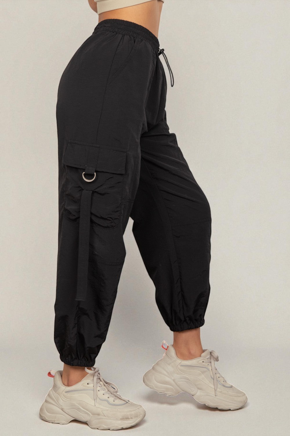 Black cargo jogger pants worn by a person on a plain background
