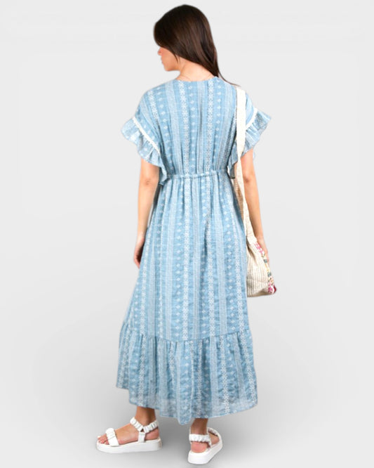 Woman wearing a blue and white striped dress on a plain background