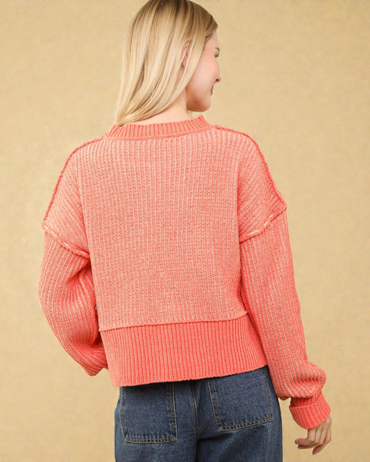 Person wearing a pink sweater with a beige background