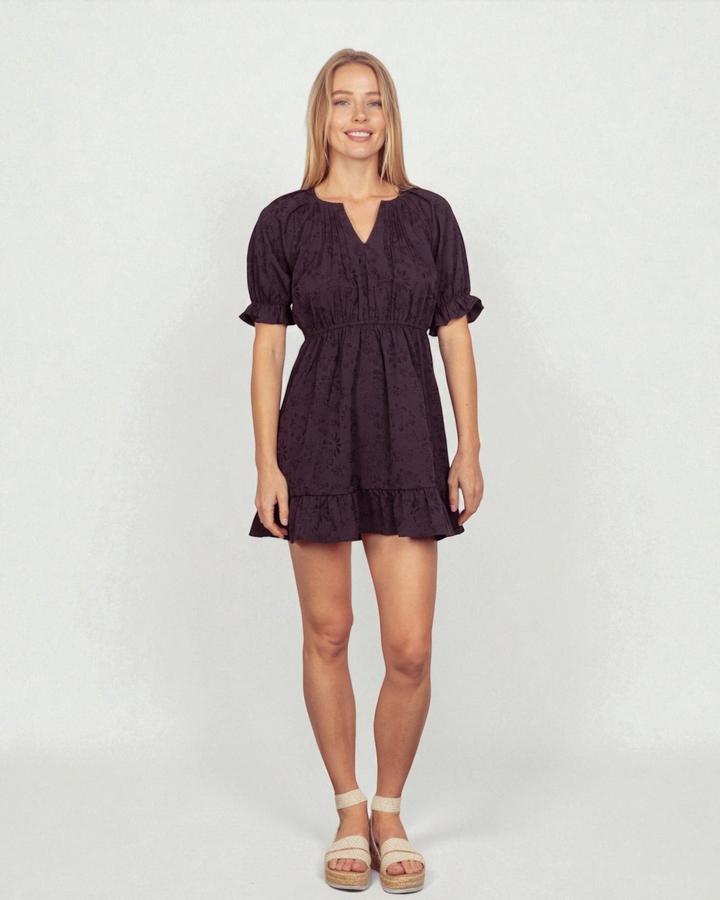 Woman wearing a dark purple dress on a white background