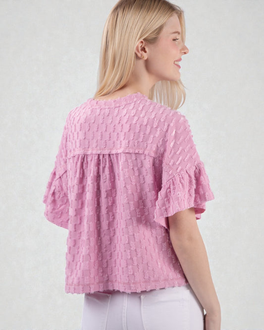 Woman wearing a pink textured blouse against a white background