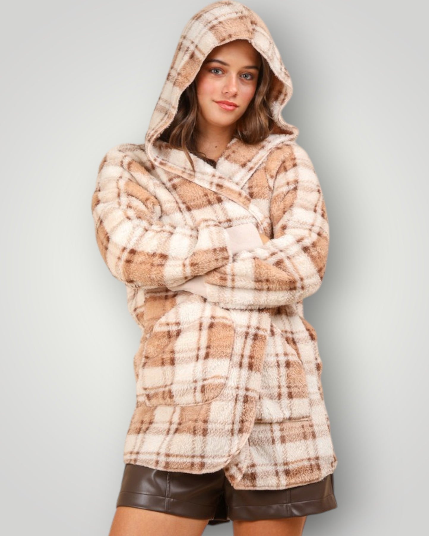 Person wearing a plaid hoodie with a plain background