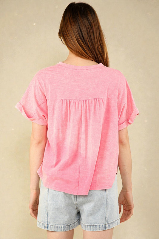 Person wearing a pink top and light blue shorts on a beige background