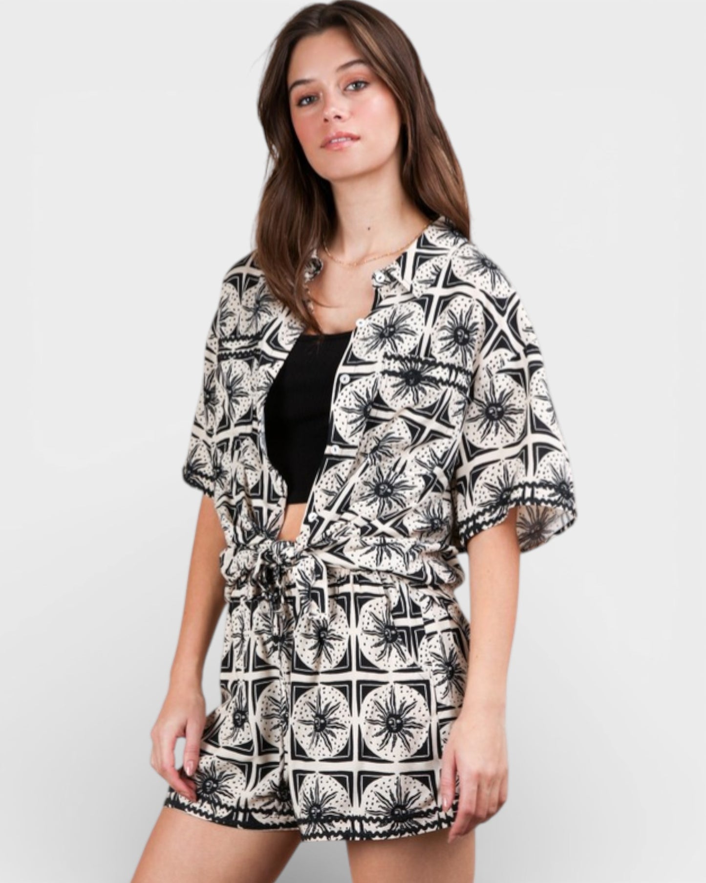 Woman wearing a black and white patterned kimono-style garment on a plain background