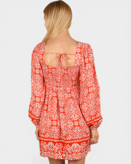 Red floral dress worn by a person on a white background